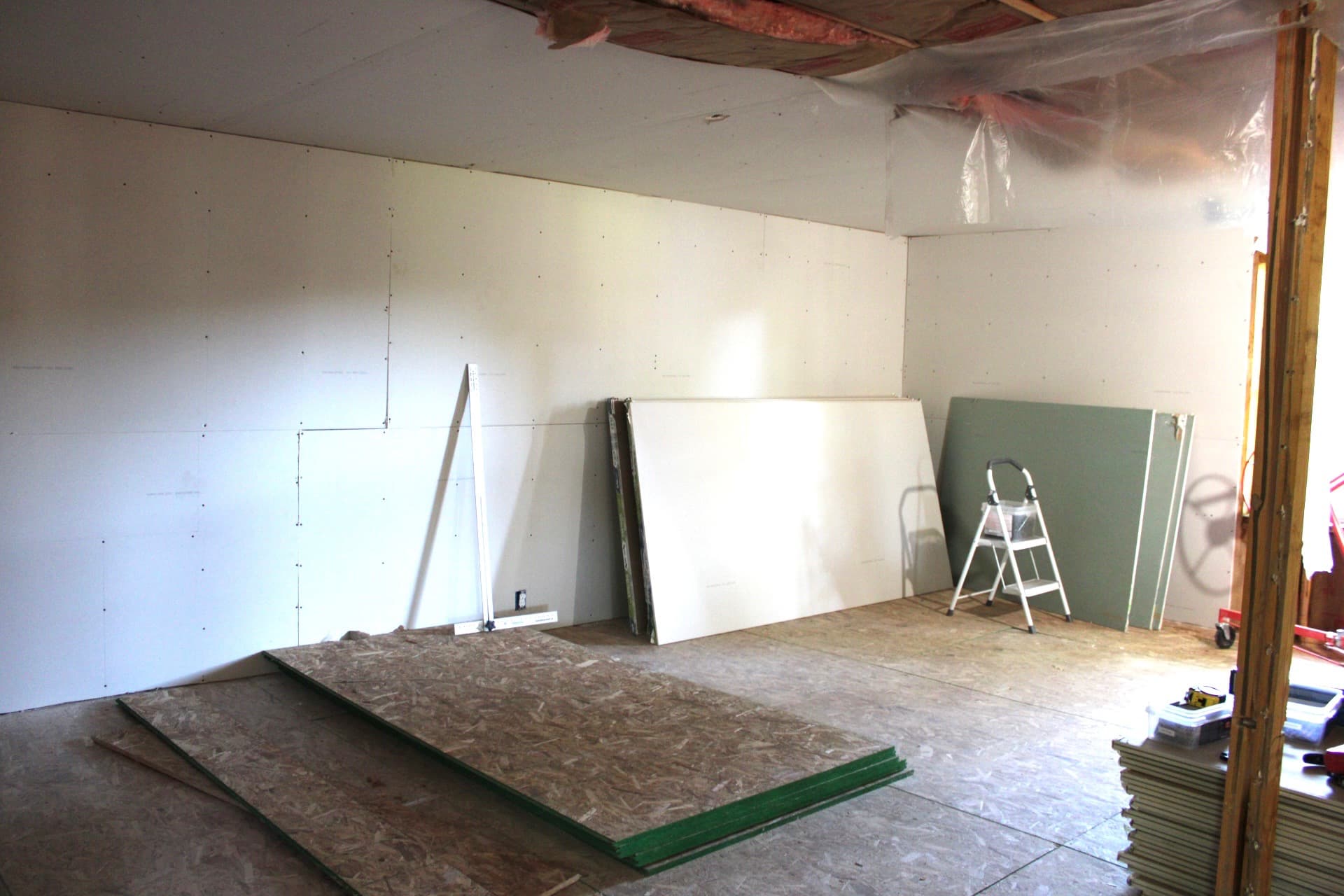 Drywall installation underway in a residential living space
