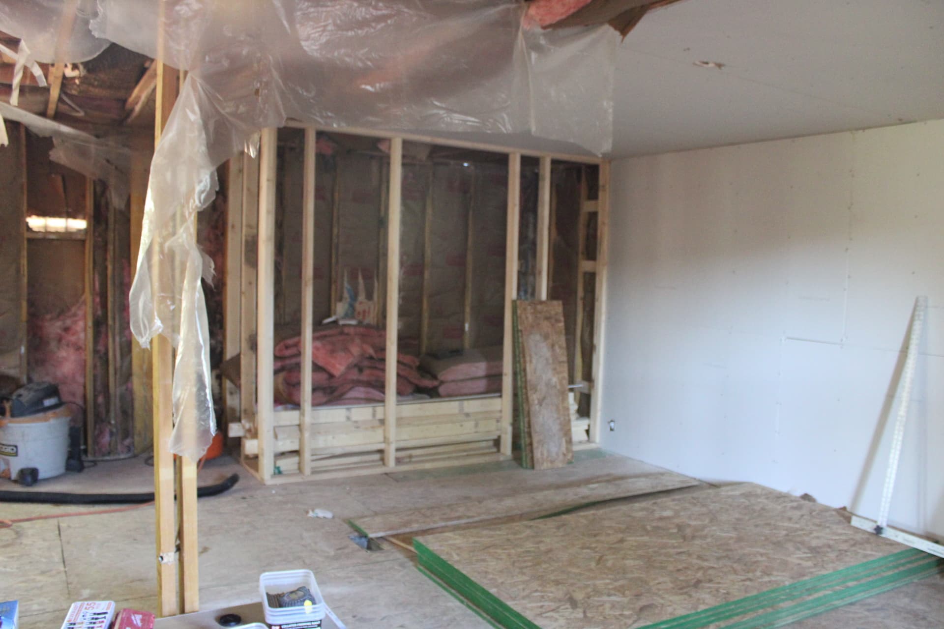 Interior wall framing with drywall staged for installation